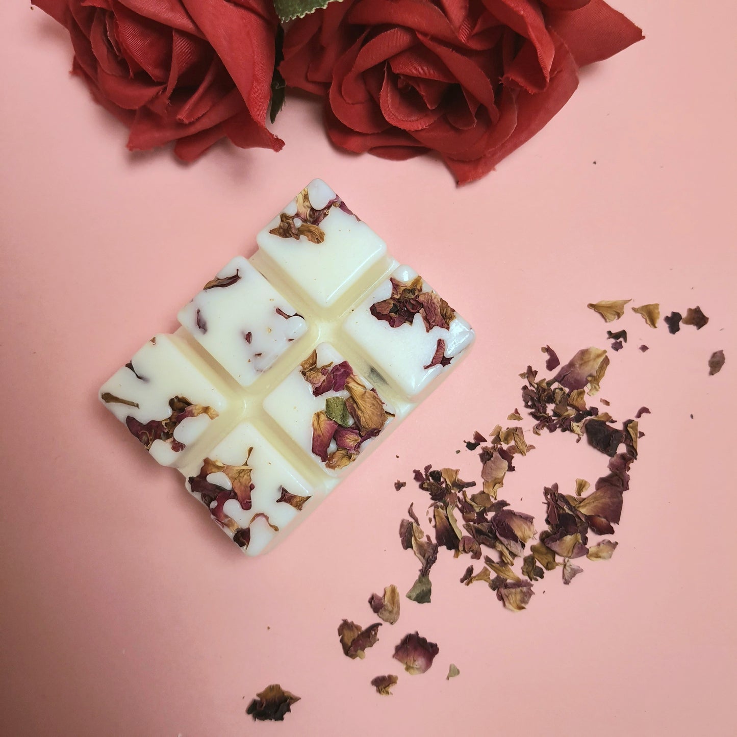 Rose & Sandalwood soy wax melts adorned with dried rose petals, a sensual spring scene with a light pink background, and wax melts surrounded by beautiful rose petals.